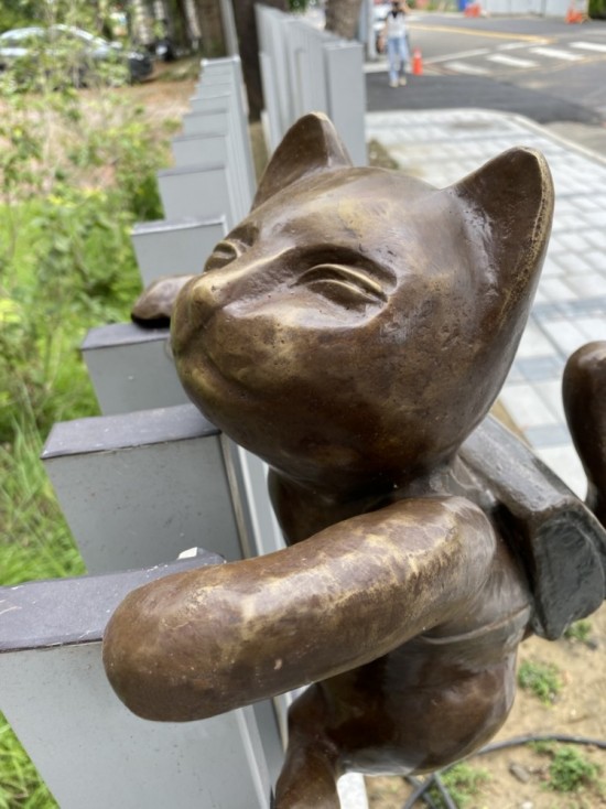 半夢(mèng)半醒的貓咪攀牆上學(xué)，摹寫著孩童們匆忙上學(xué)的日常，藝術(shù)家─曾永玲發(fā)揮天馬行空的想像投設(shè)其中。