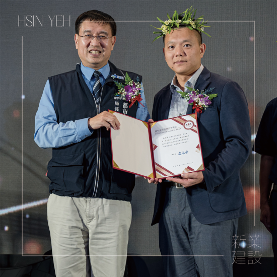 「2025臺(tái)中建築獎(jiǎng)?lì)C獎(jiǎng)典禮」，以金馬獎(jiǎng)模式現(xiàn)場(chǎng)揭曉各獎(jiǎng)項(xiàng)得主，由頒獎(jiǎng)人臺(tái)中市都市發(fā)展局 李正偉局長(zhǎng)(左一)，恭賀新業(yè)建設(shè) 吳志輝建築師(右一) 榮獲殊榮。