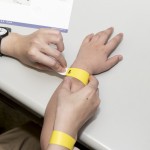 活動(dòng)開(kāi)始之前，工作人員協(xié)助大、小朋友們戴上分組的幸運(yùn)手環(huán)。