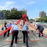 新業(yè)建設 穆椿松名譽董事長(右一)帶領新業(yè)團隊以金鏟鏟起沙堆，象徵工程進度順利，動土開工大吉大利！