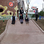 新業(yè)建設(shè)卓勝隆董事長(zhǎng)(中)與來(lái)賓童心大發(fā)，一起玩溜滑梯。