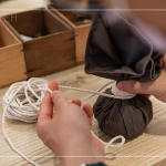 抓取藥材，包起、壓緊、編綁成球，感受草本植癒之外，還增添了另一份手感溫度，透過捶打、按壓，舒緩疲勞、釋放壓力。