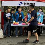 現(xiàn)場新業(yè)建設(shè)穆椿松名譽董事長（左二）與卓勝隆董事長（左一）引領(lǐng)大家，加油吶喊給予跑者支持。