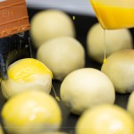 刷上蛋黃液，點(diǎn)上芝麻裝飾，圓潤蓬鬆的蛋黃酥即將穿上金黃酥脆的外衣。