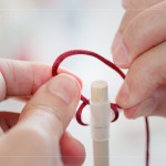 引線、綁結(jié)，將喜氣洋洋的紅線固定在燈籠之上，已完成吊掛的功能。