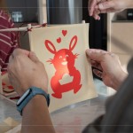 剛完成的剪紙，辛卯喜兔浮躍紙上，手捧著元寶寓意財源滾滾，家族發(fā)揮創(chuàng)意增添
兩顆小愛心，俏皮且生動的趣味十足。