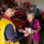 「阿嬤呷飯囉!」，甘霖基金會志工將便當送到獨居長輩手中的同時，也不忘送上一兩句暖心的問候。