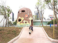 新業(yè)建設(shè)董事長卓勝隆童心大發(fā)，在碉堡地景溜滑梯。