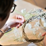 將滿(mǎn)天星修剪成想要的長(zhǎng)度，一束一束裝飾上藤圈，讓花圈增添了一份手感的溫度。