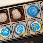 宇宙巧克力 - 將香草莢獨特的香氣與可可豆完美融合，巧克力都是親手繪製，星空圖樣包含著繽紛的內餡，每一口都能感受到驚喜。