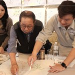 新業(yè)建設(shè)卓勝隆董事長(圖中)與工地主任，共同探討樹木容易死亡的原因，及分析各面向可能的解決方案。